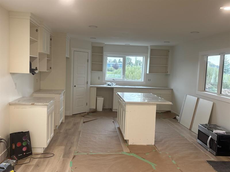Cream shaker kitchen with open upper cabinets around a window and a centre island